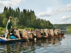 Большой катамаран с туристами и собакой плывёт по Чусовой, гид у весла на носу